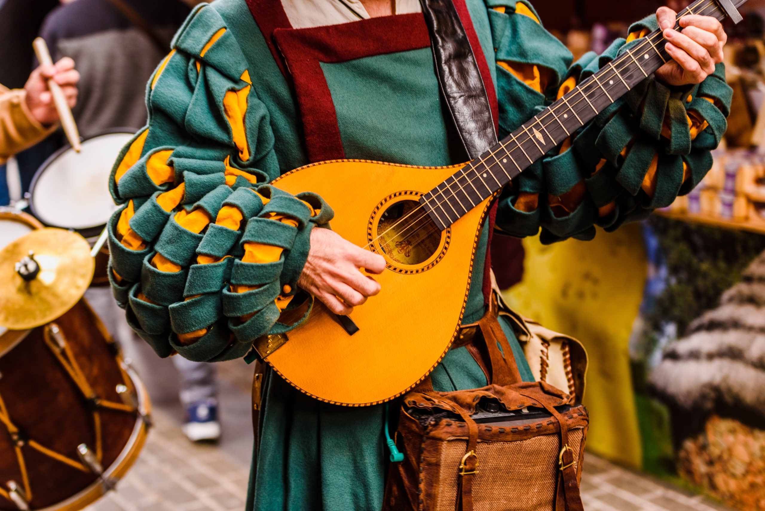 Medieval troubadour playing an antique guitar.