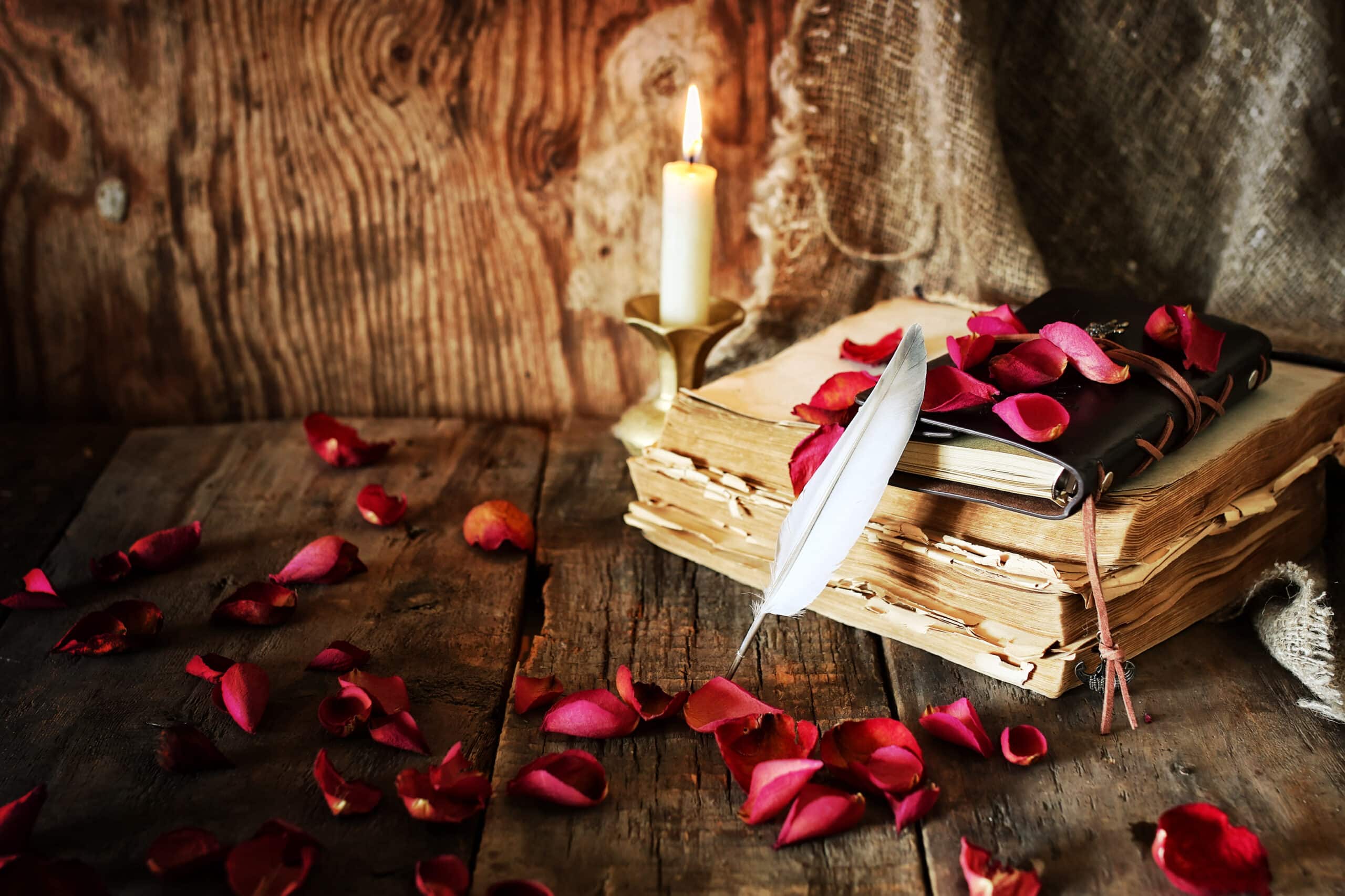 a book, quill pen, and a lit candle