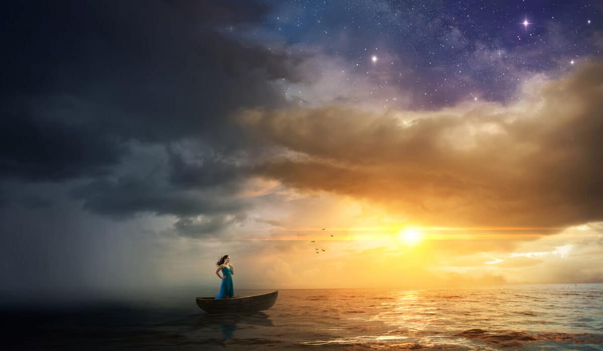 Woman standing on a boat in the sea with beautiful galactic view of the sunset and evening sky