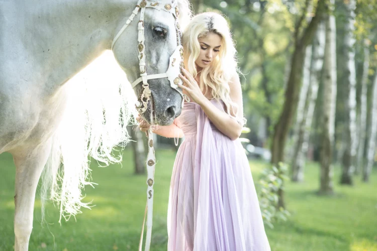 Blond cute woman with a stunning white horse