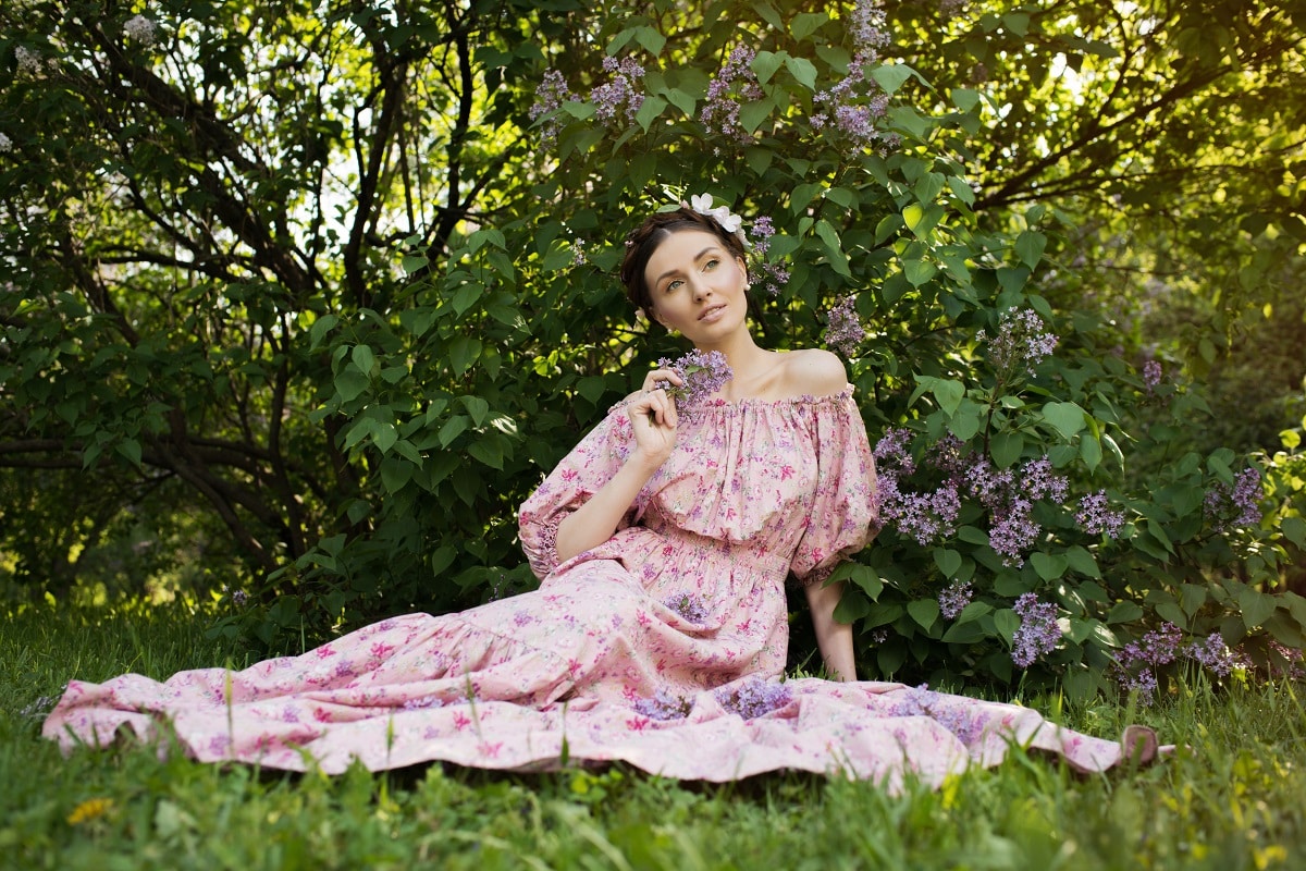 beautiful woman dressed in pink dress relaxing in the garden