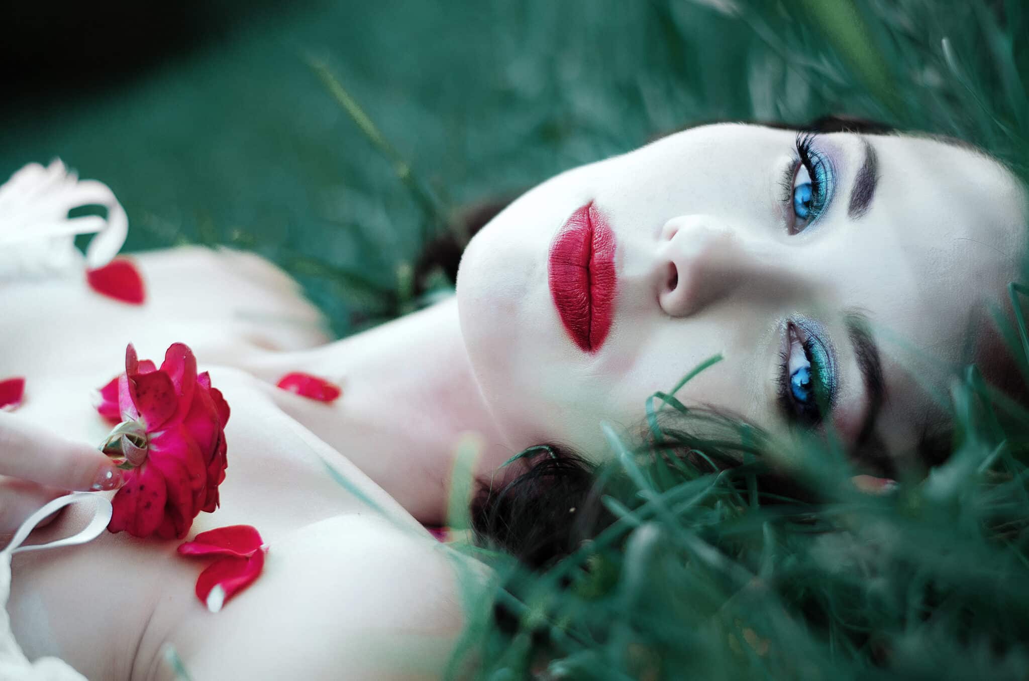 beautiful girl lying on the grass with roses