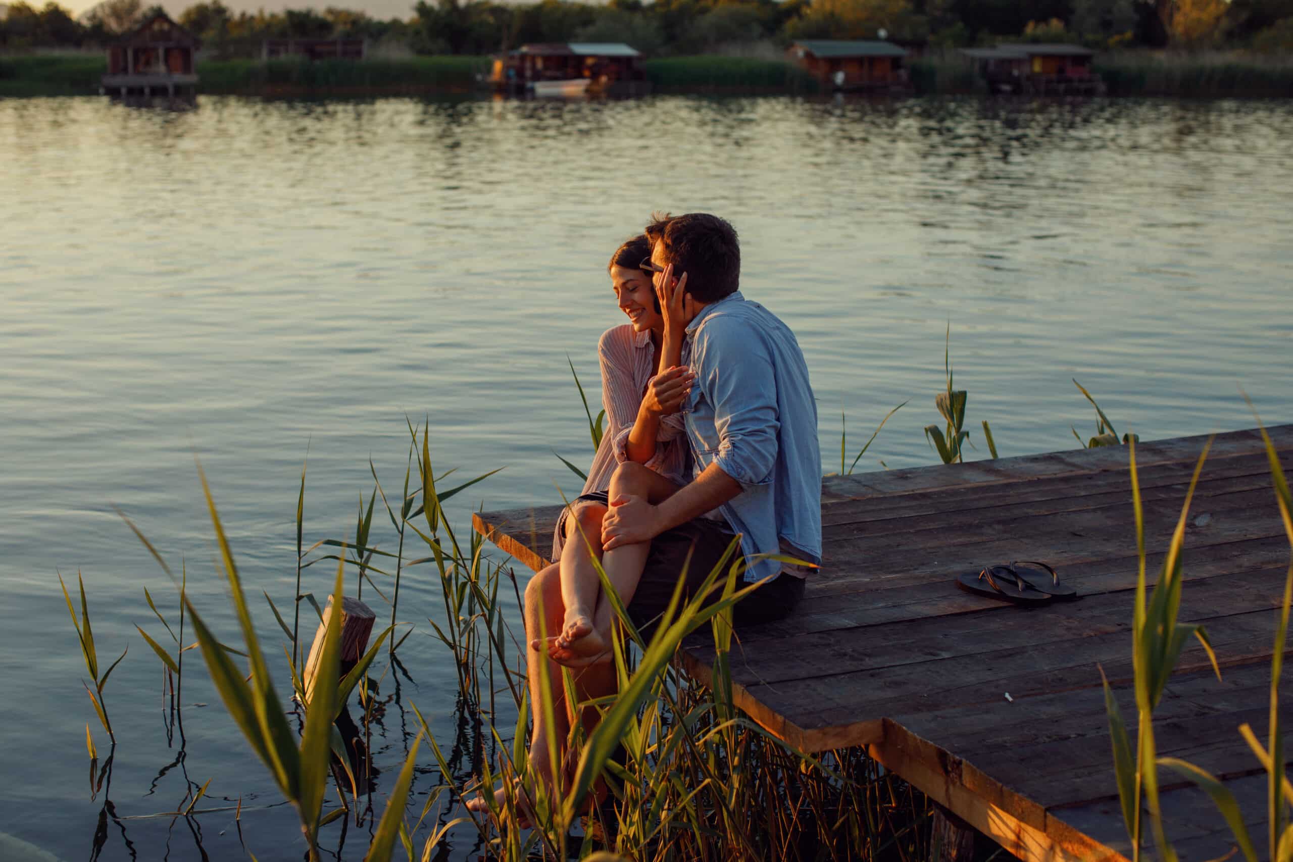 Young loving couple enjoys by the river during the sunset