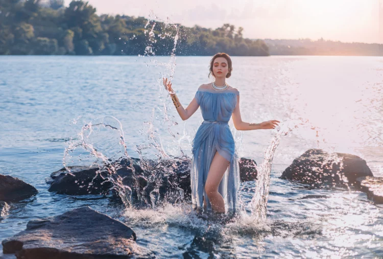 Greek mythical woman in blue gown emerges from the lake