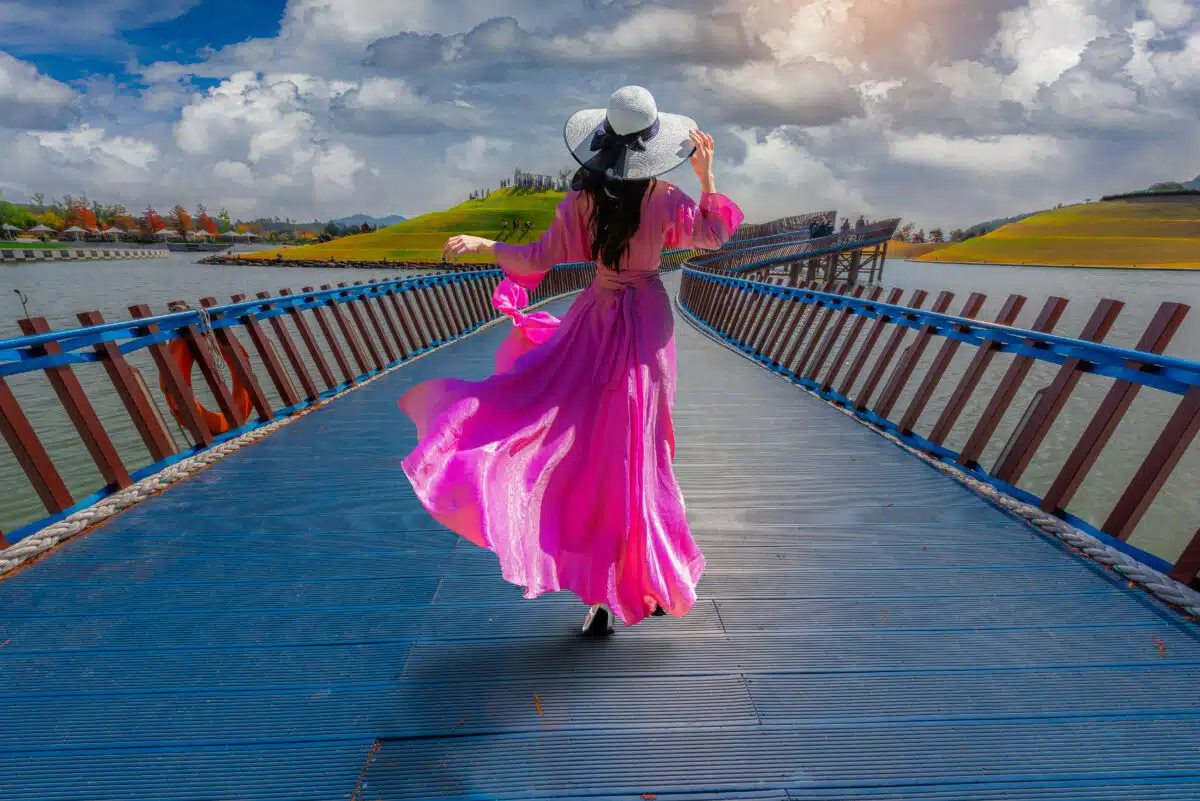 Asian woman walks on a blue bridge in Suncheonman Bay National G
