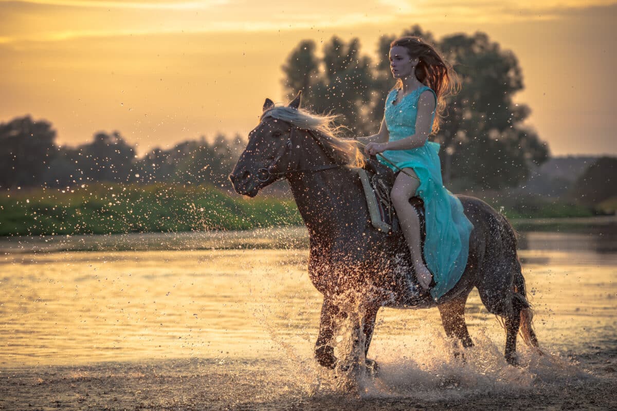 Girl riding horse on water surface