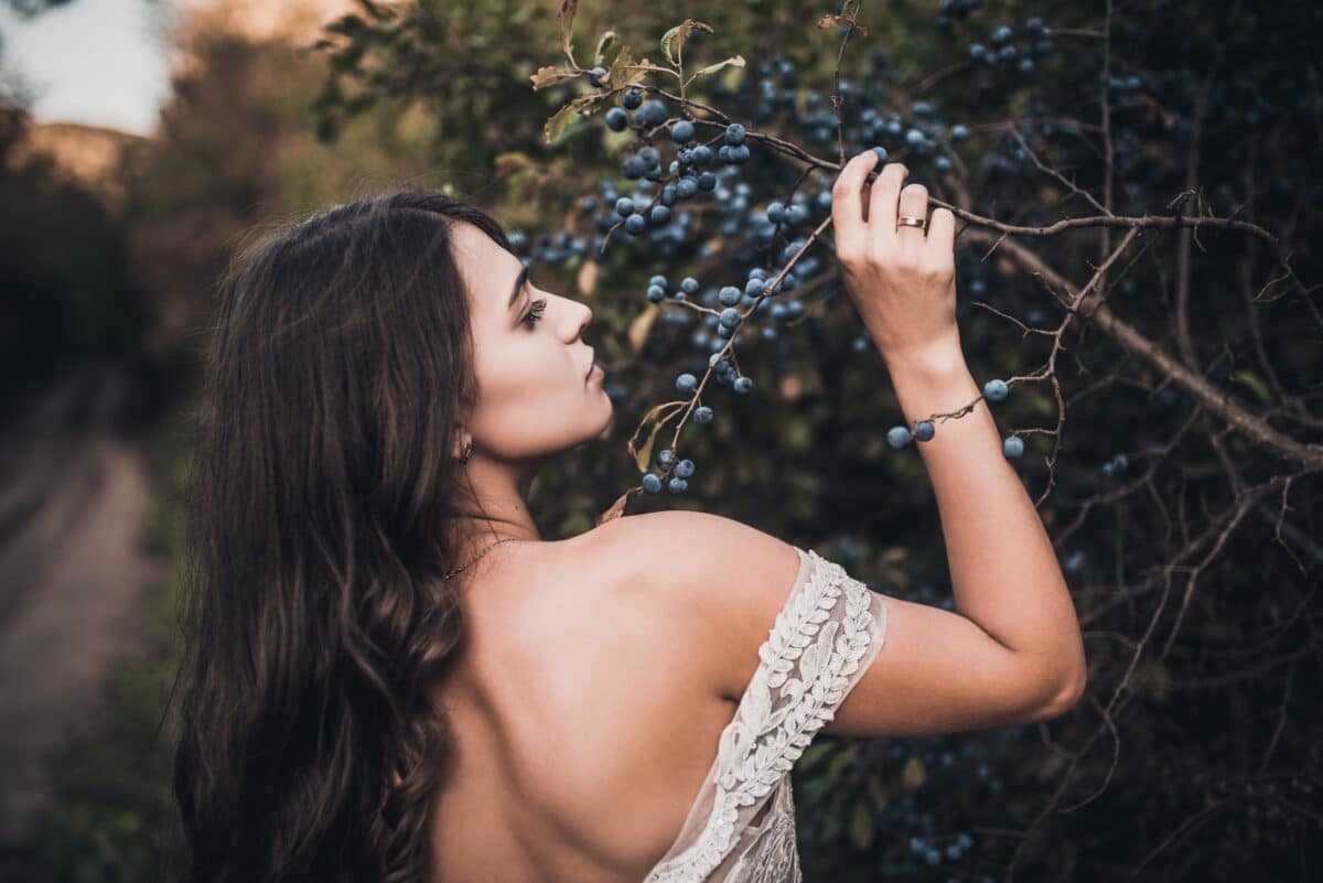 long curly-haired lady picking blueberries