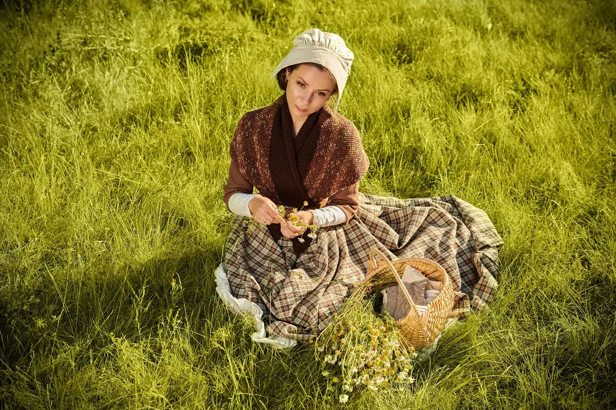rural scottish girl in traditional clothes sitting on the grass