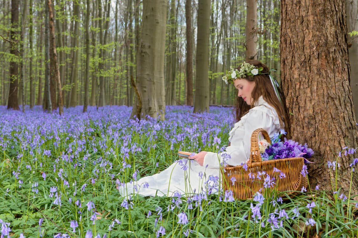 Victorian girl in bluebells forest