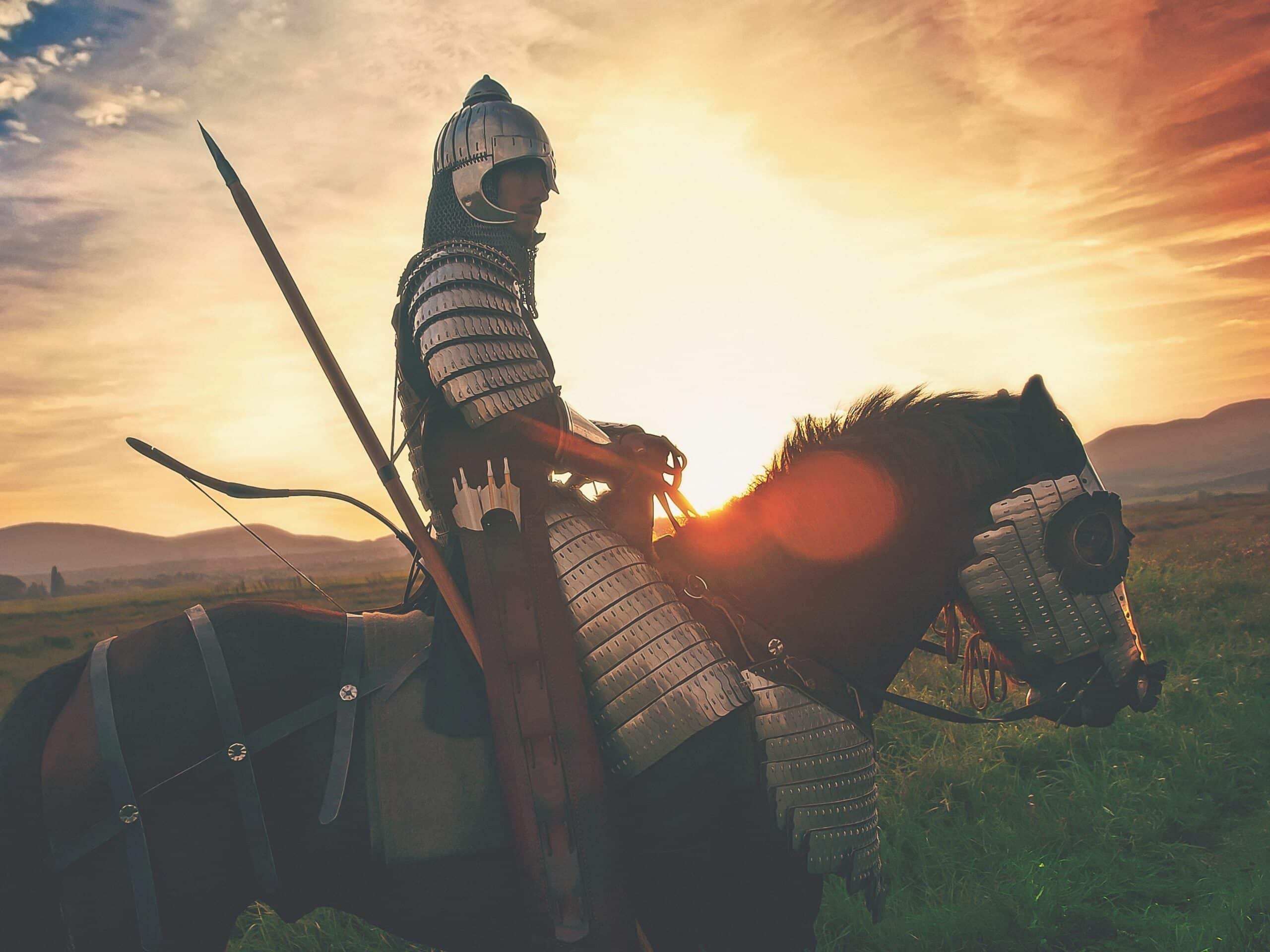 male knight riding his horse at sunset