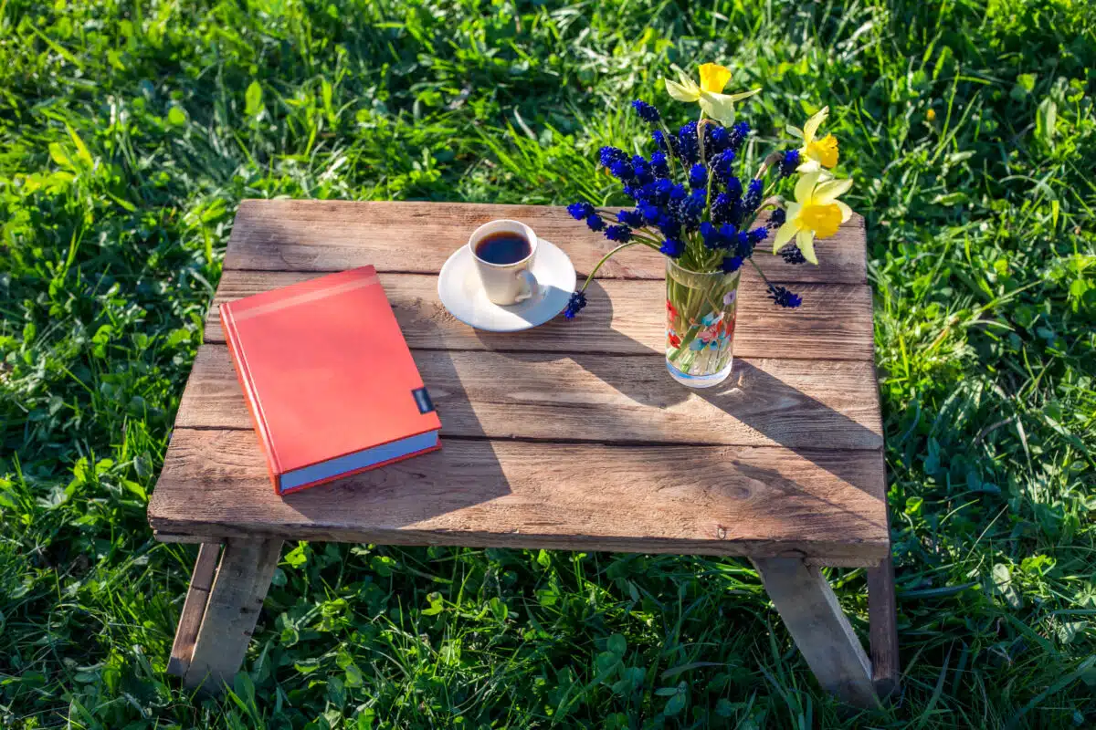 book flower and coffee on a wood in nature
