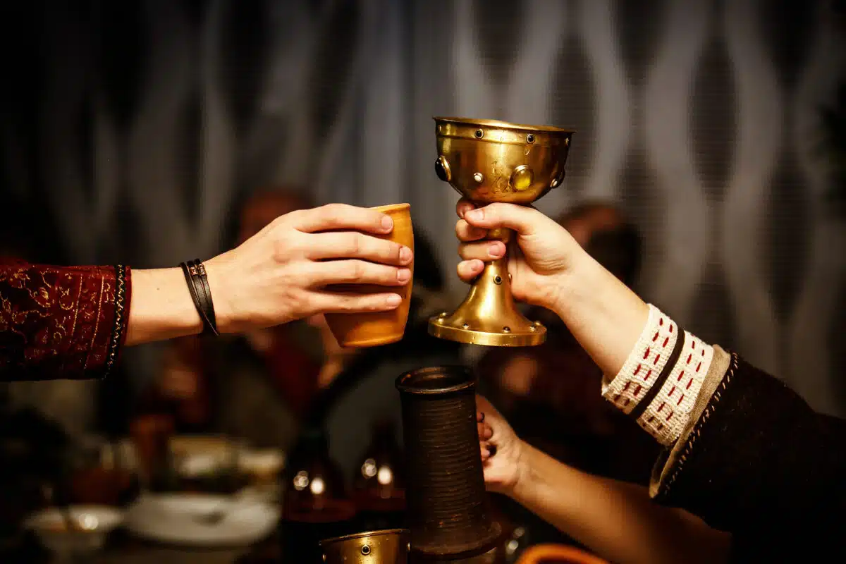 people clink cups on a medieval feast