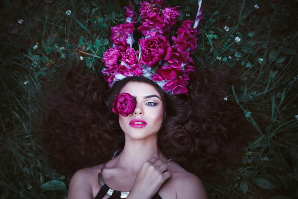 Beautiful woman with crown from purple peonies