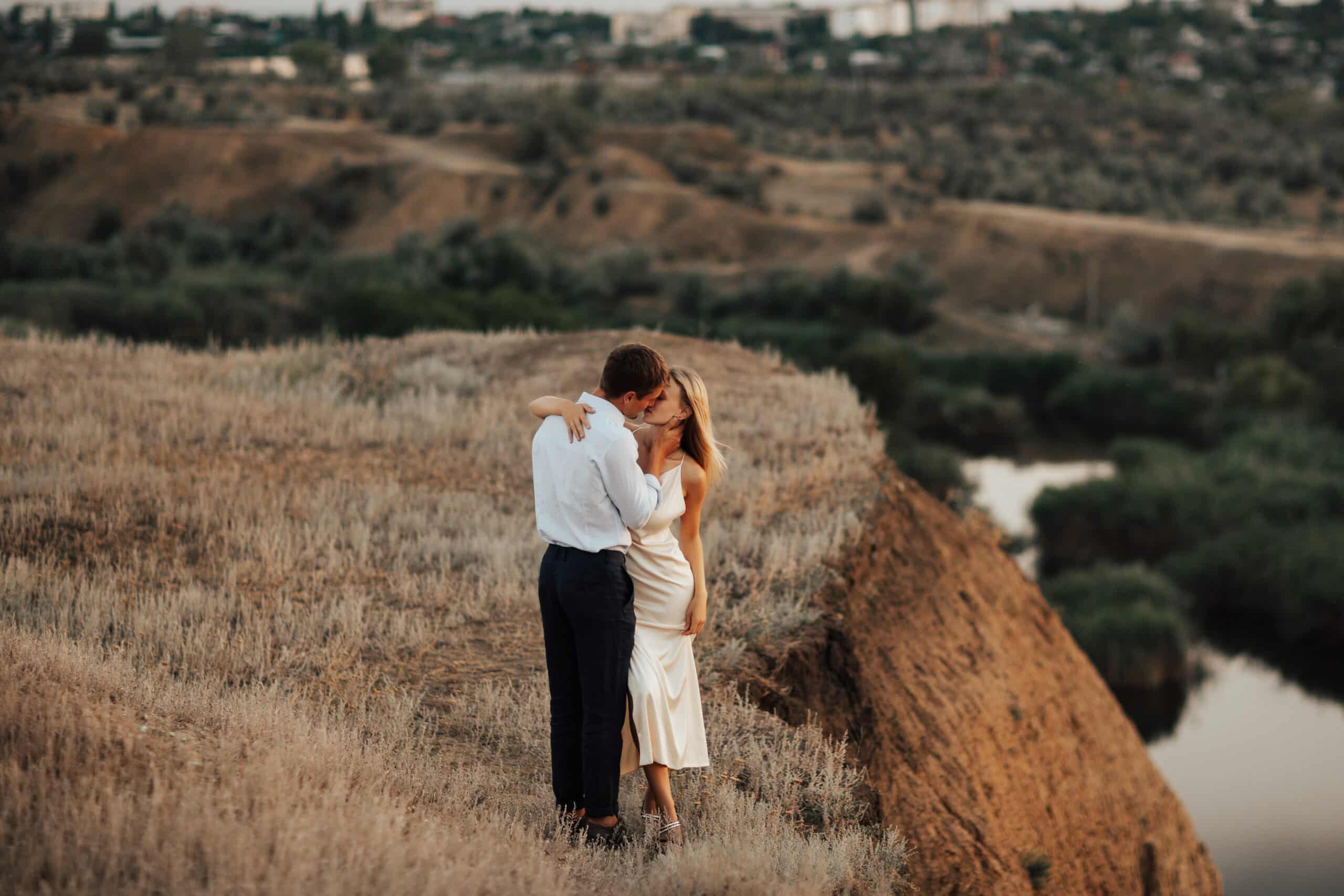 Two lovers embracing on top of a hill overlooking the city
