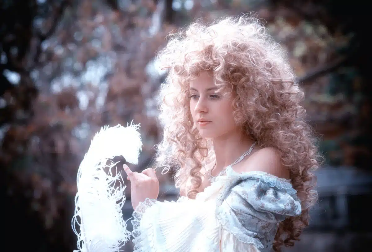 a pensive curly blond haired noble woman with a white feather