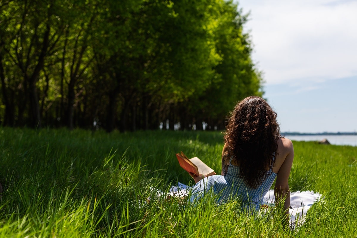 Woman reading a book in the forest.