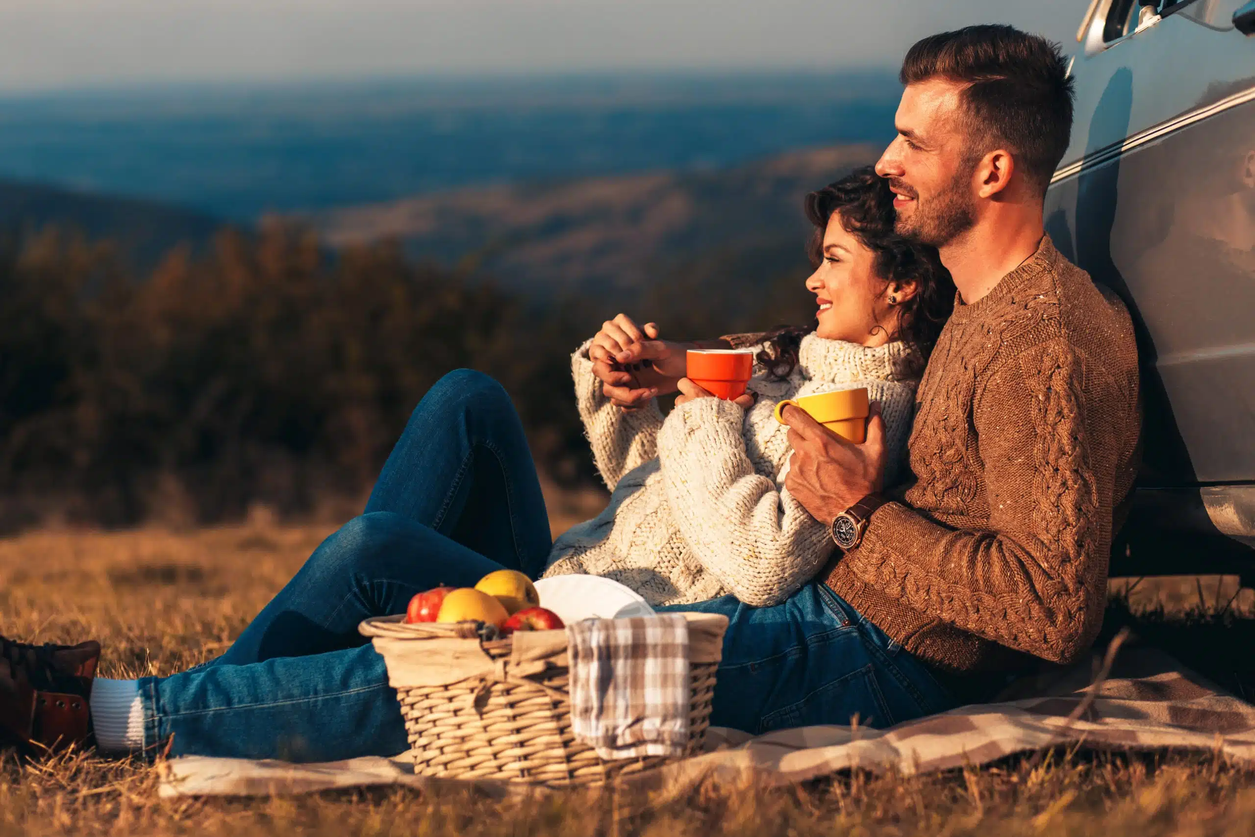 Beautiful young couple enjoying picnic time on the sunset.