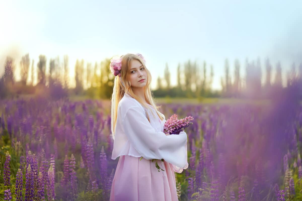Beautiful blonde girl in a fantasy outfit dress on a field of lavender
