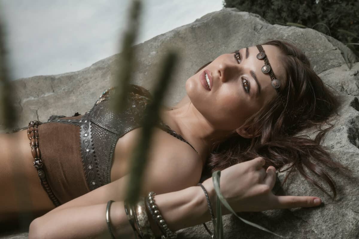 Young beautiful woman dressed in a leather wear lying on the ground