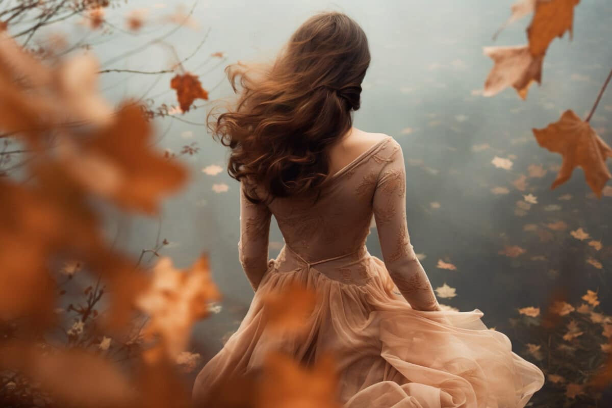 a romantic woman in a dreamlike autumn forest with falling leaves