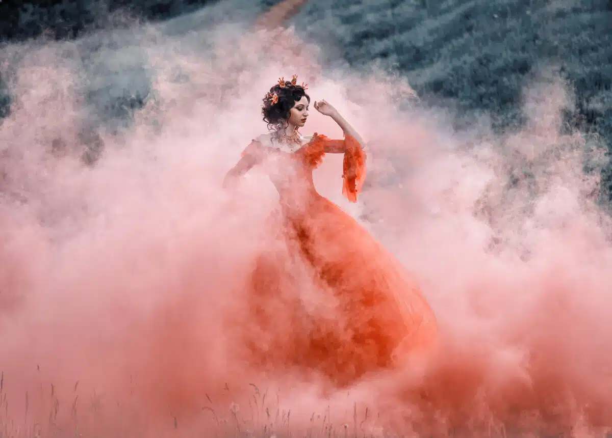 Lady in a luxury lush red dress swirls in the smoke,fantastic sh