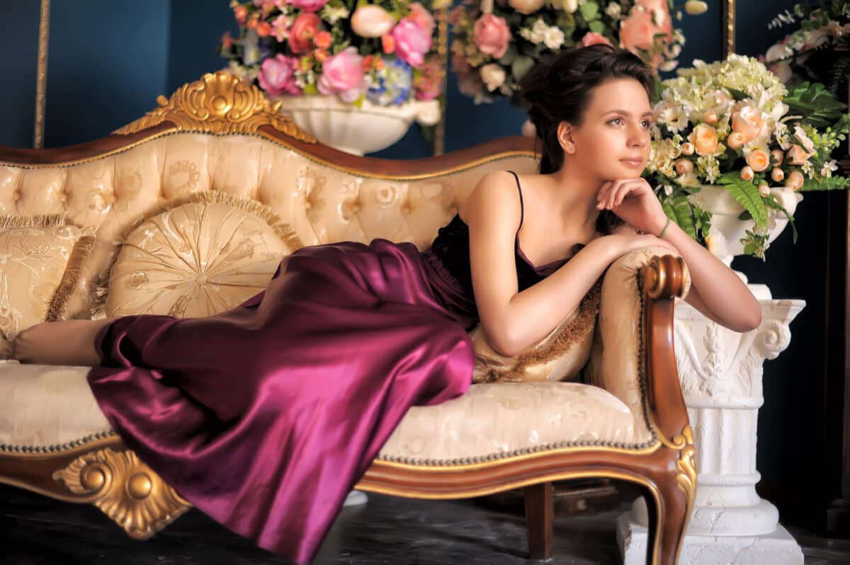 a pretty girl in a purple dress relaxing in a luxurious sofa