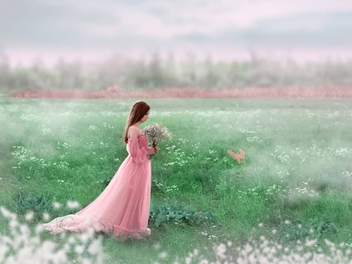 A young girl walks in a field of white flowers