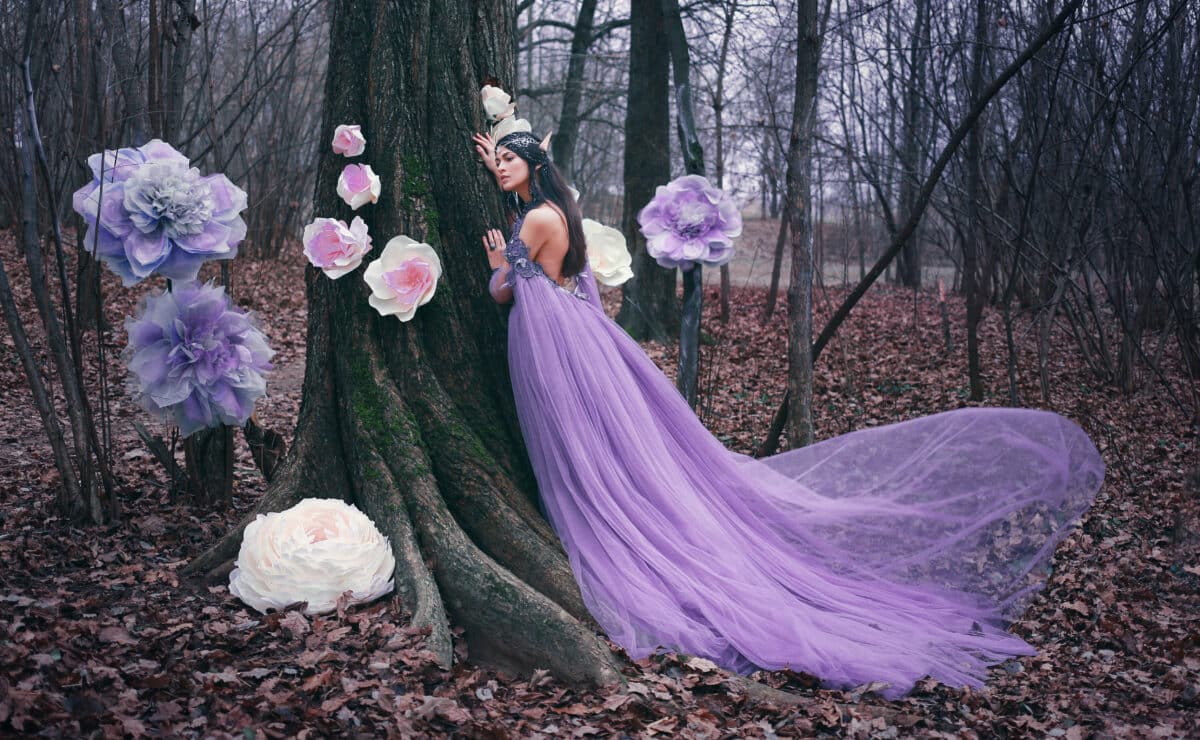 elf proncess in violet dress among flowers in forest