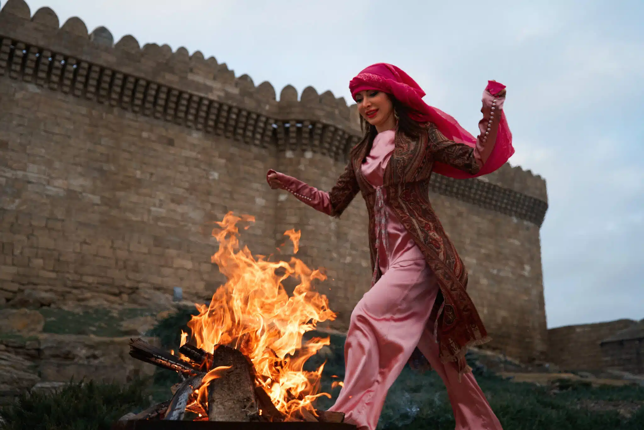 Traditional Azerbaijani Novruz holiday celebration with beautiful girl Jumping over the fire