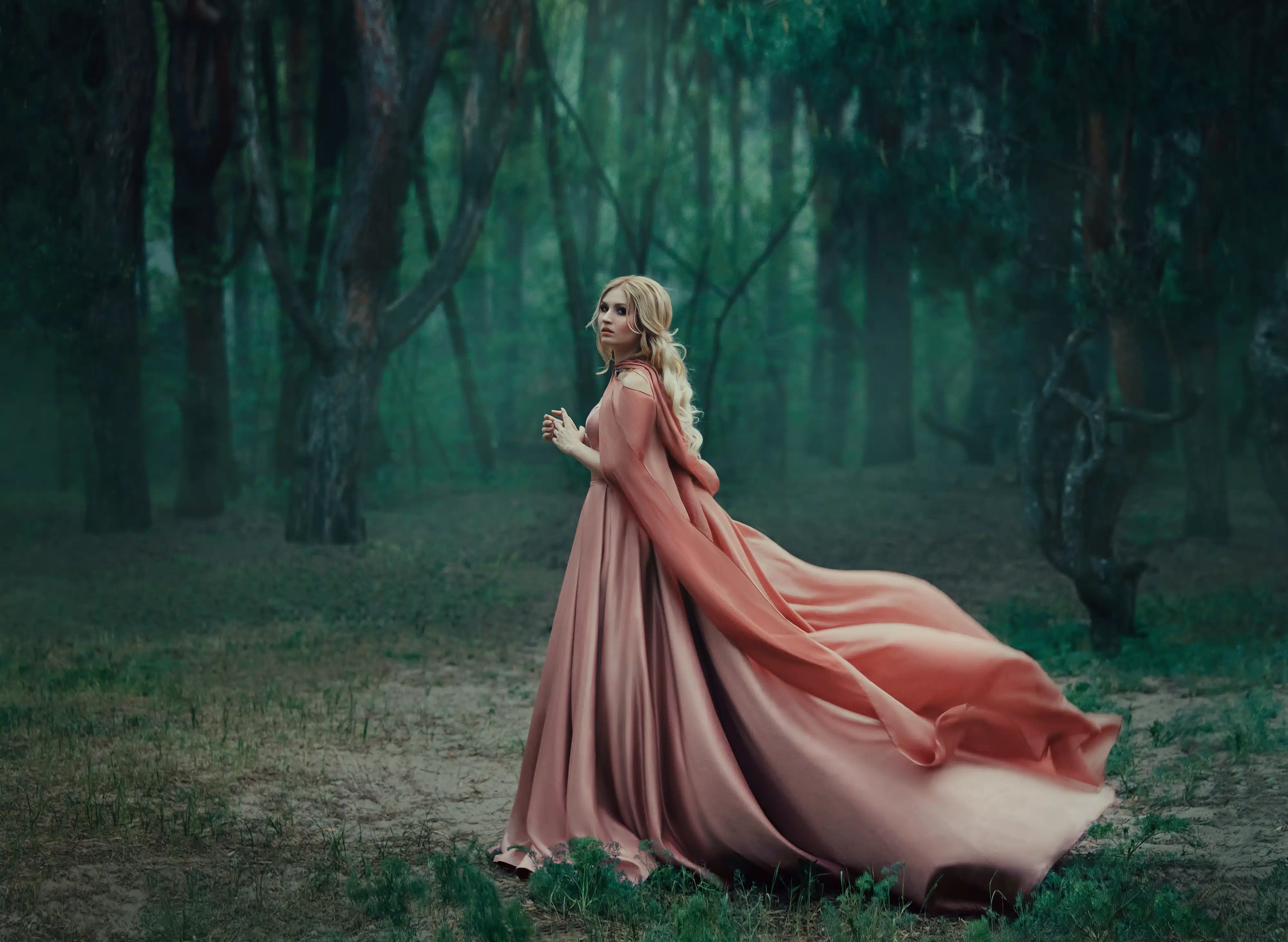A mysterious blonde girl in a long pink dress with a train and a raincoat that flutters in the wind.