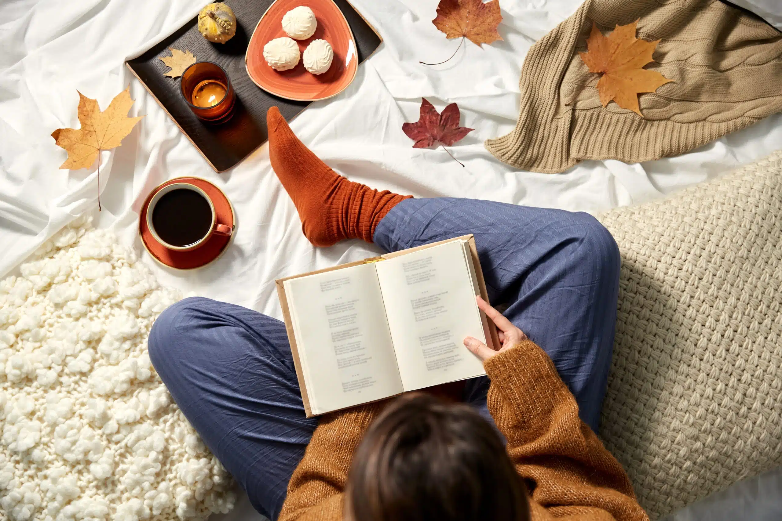 young woman reading book at home in autumn