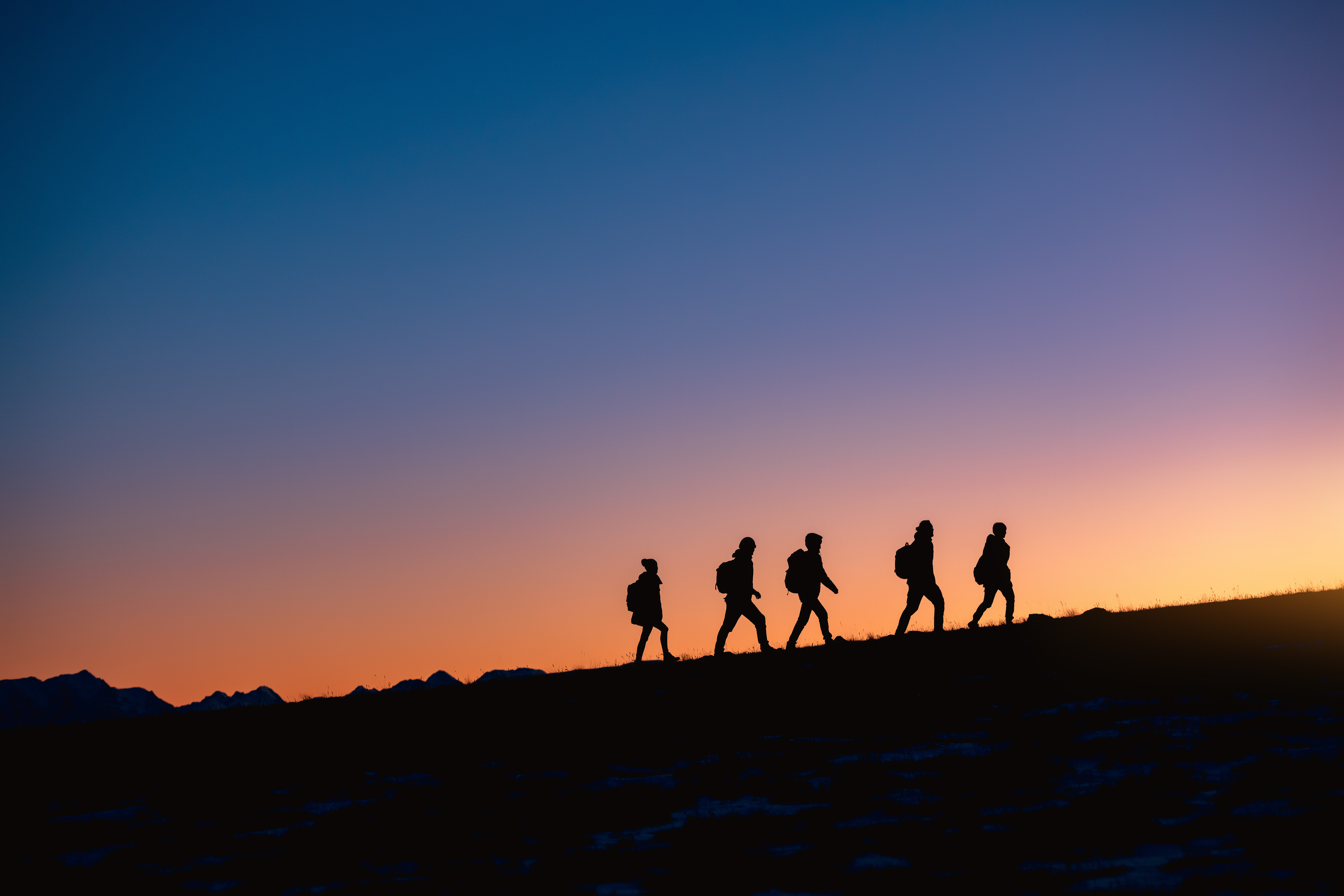 Group of hikers at sunset mountain