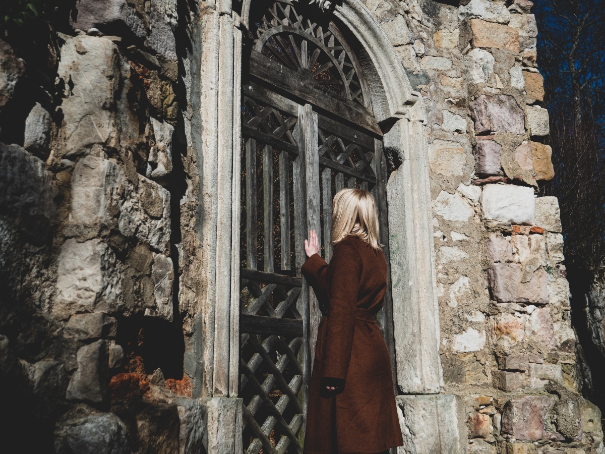 Blonde woman near ruins of old door in a castle in South Poland