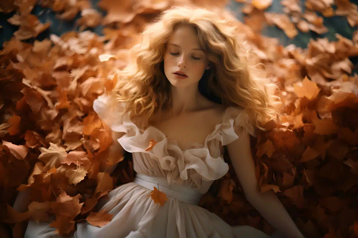 a nymph with wavy blonde hair, in the autumn pile of leaves 