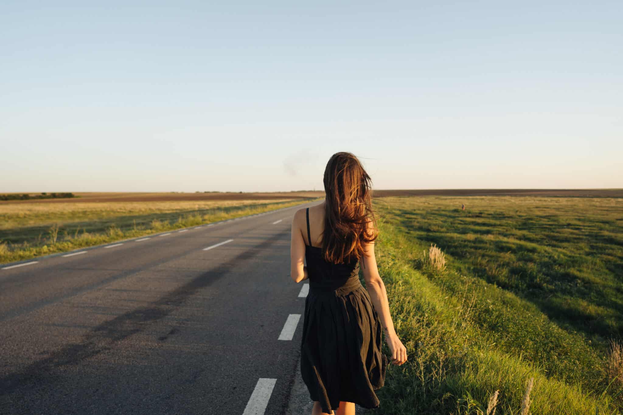 A young girl is walking along the road.