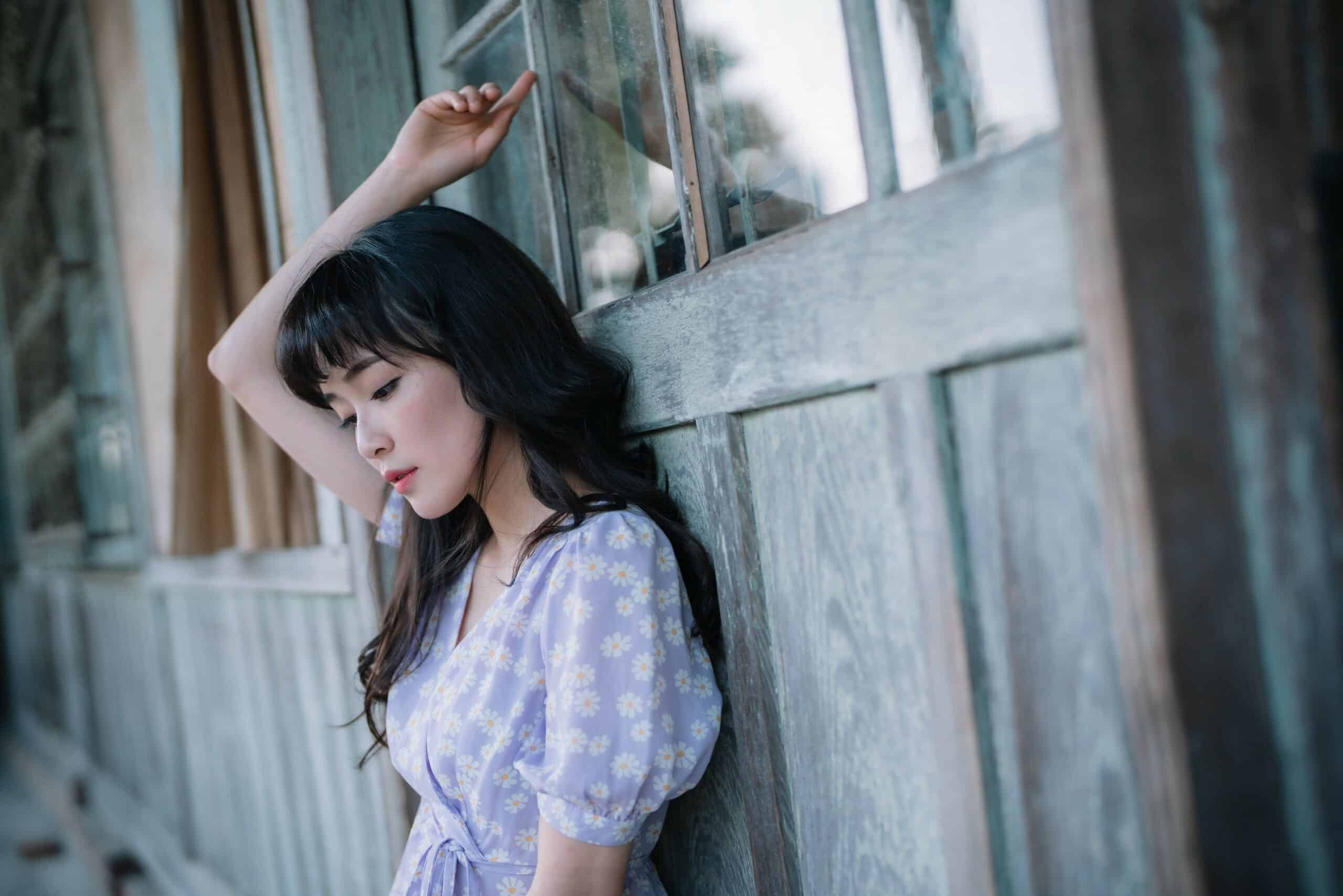 Pretty Asian girl outdoor in the countryside standing by wooden door in rustic theme.