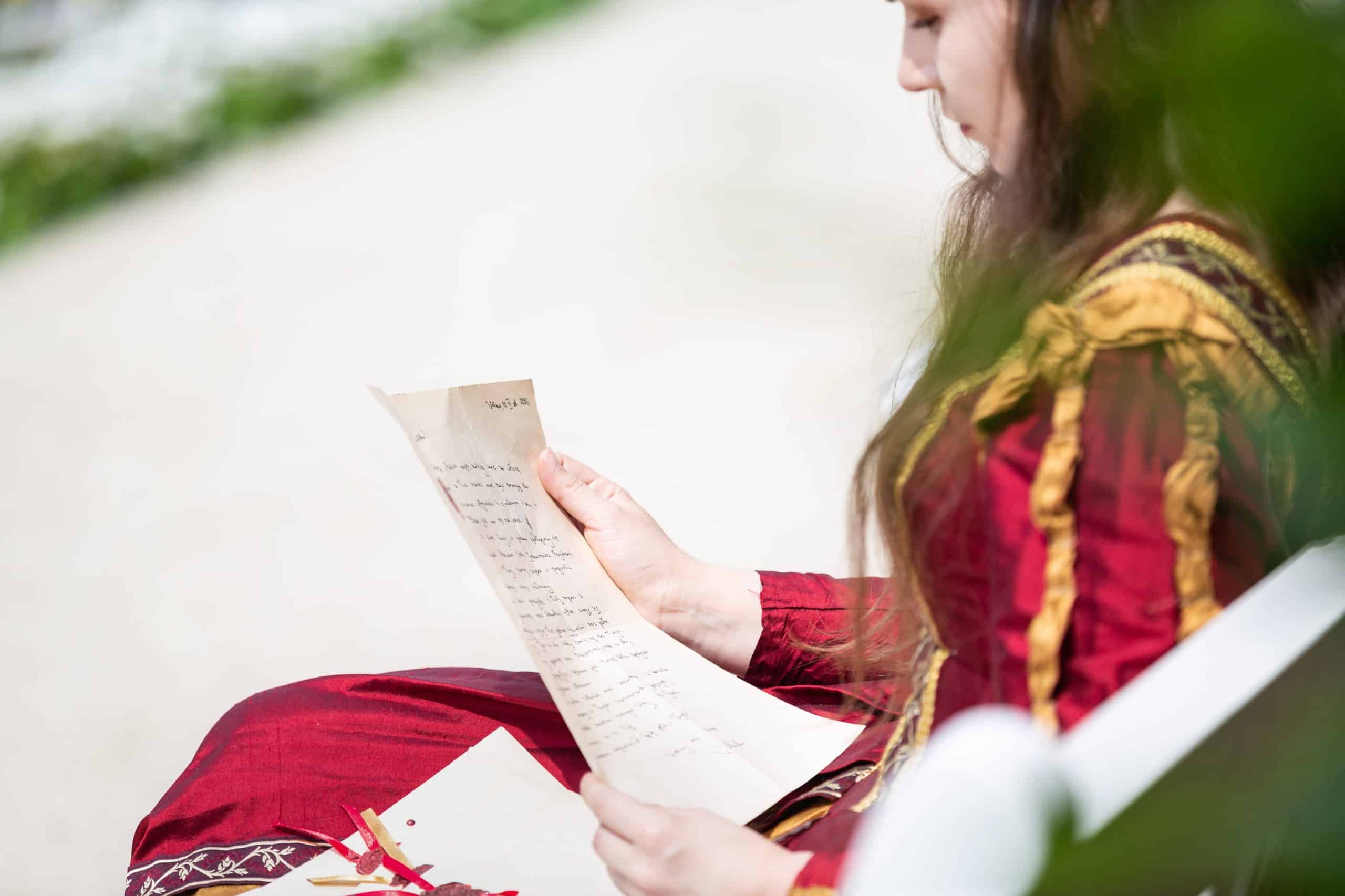 Woman in renaissance dress reading a letter.
