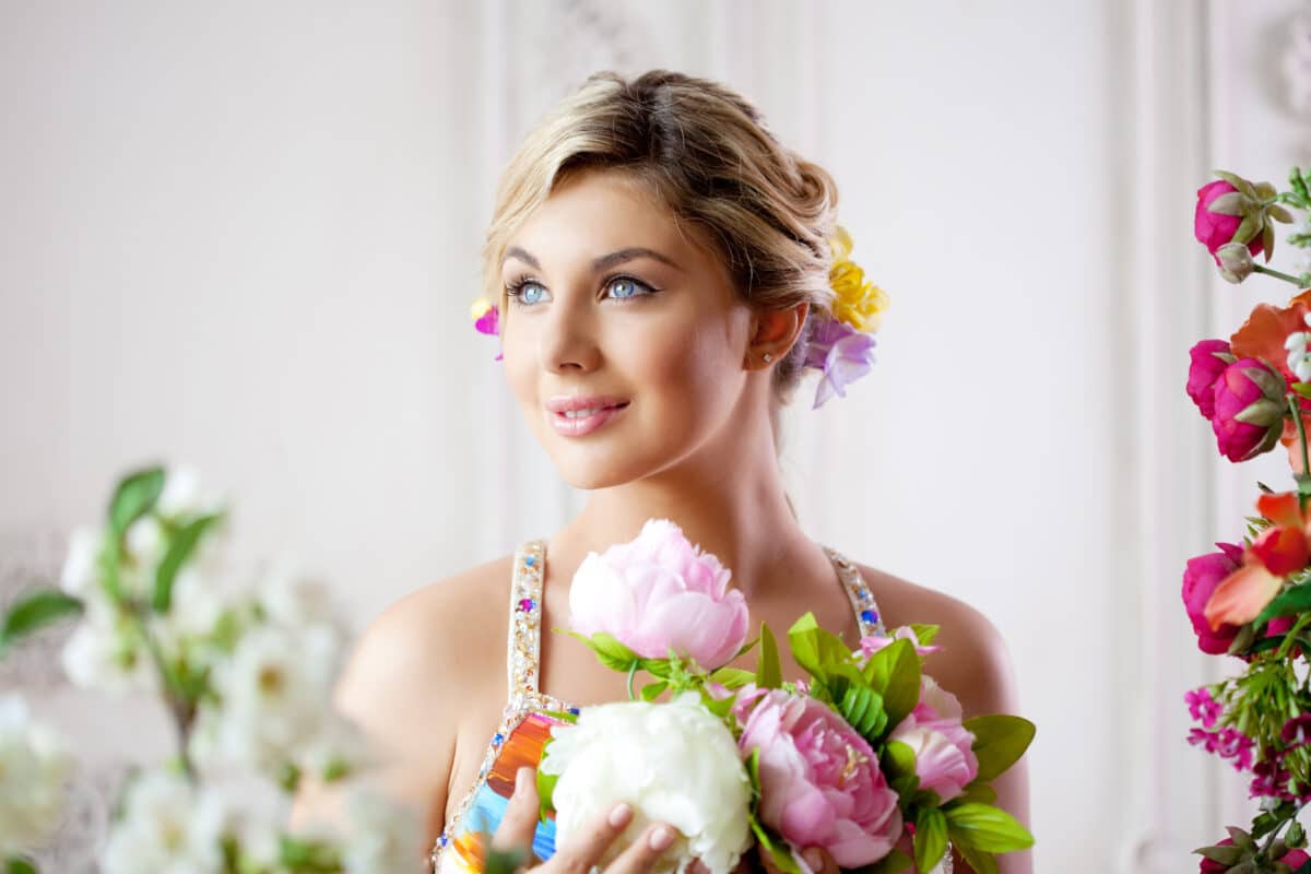 Luxury blonde woman holding pink and white peonies 