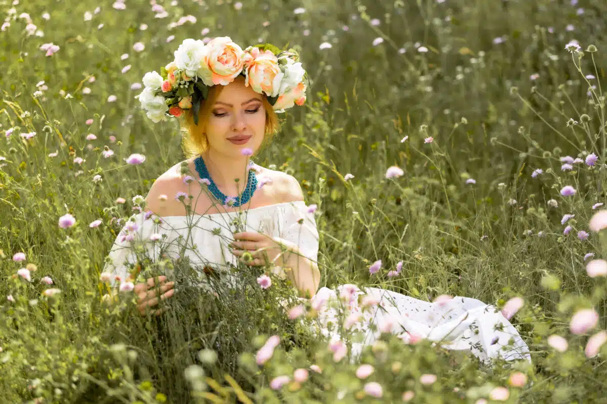 woman with a bouquet of wildflowers on a summer meadow on a sunny day