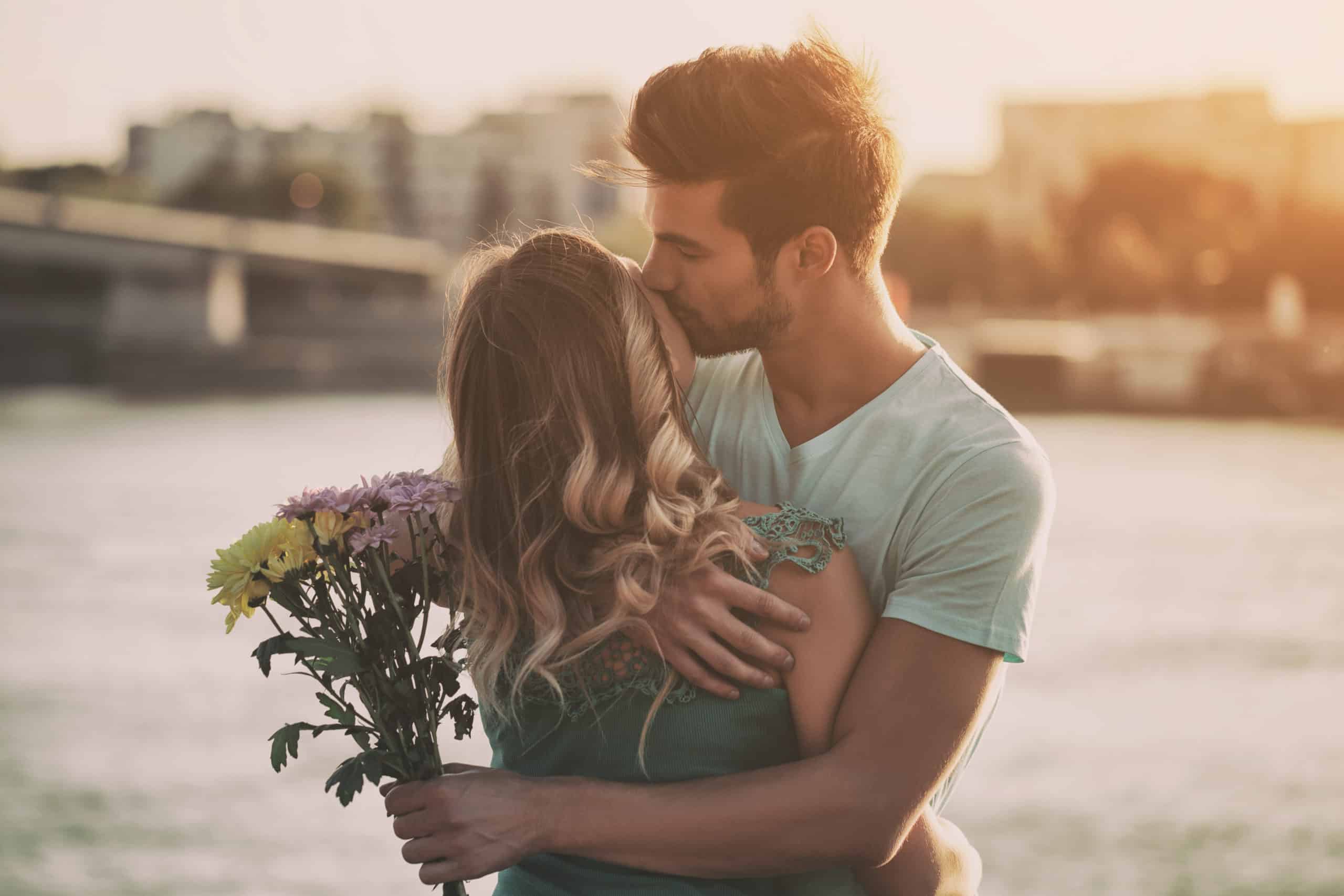 Young man is giving beautiful bouquet of flowers to his girlfriend.