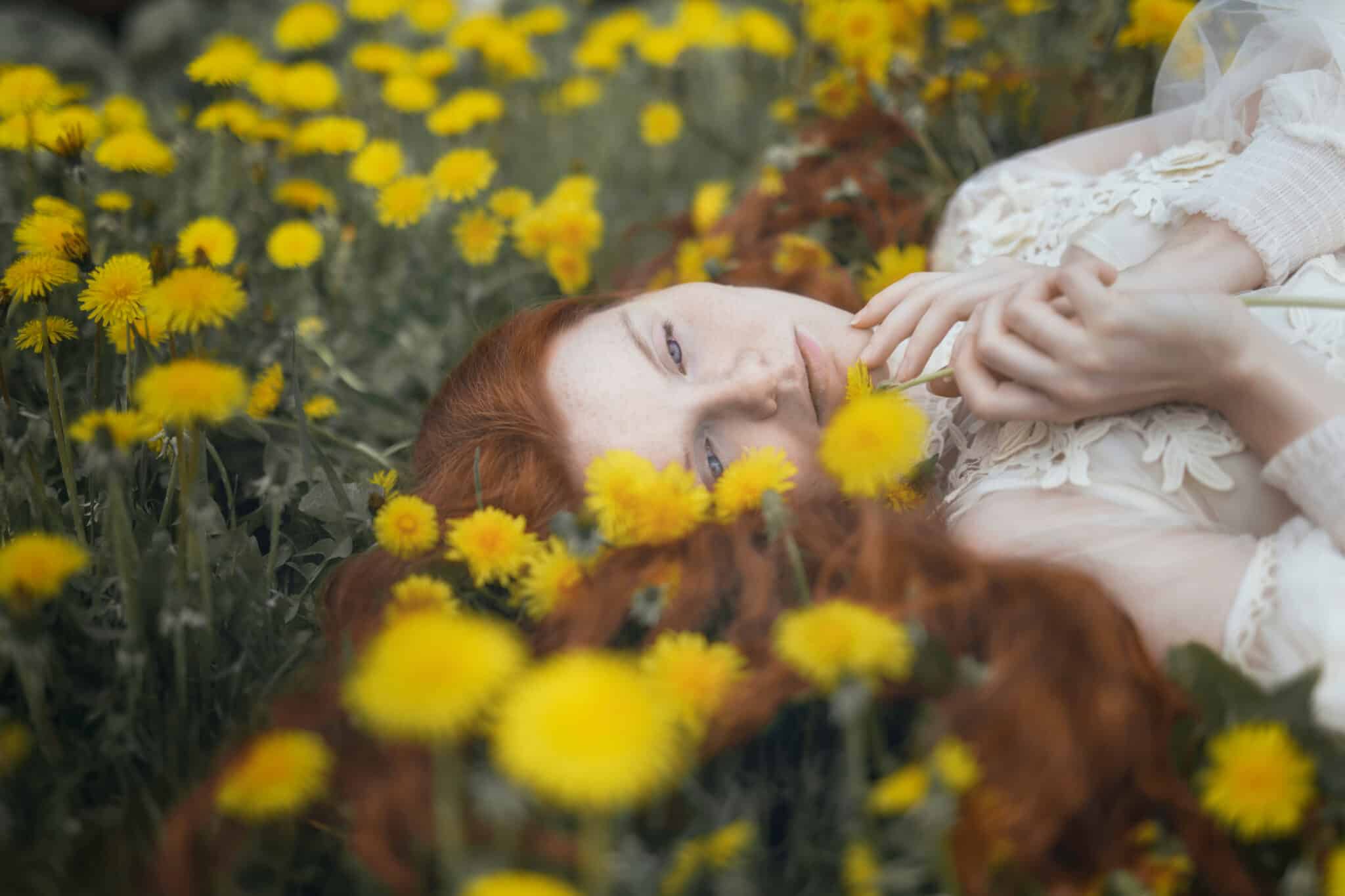 mysterious red-haired woman among yellow dandelions