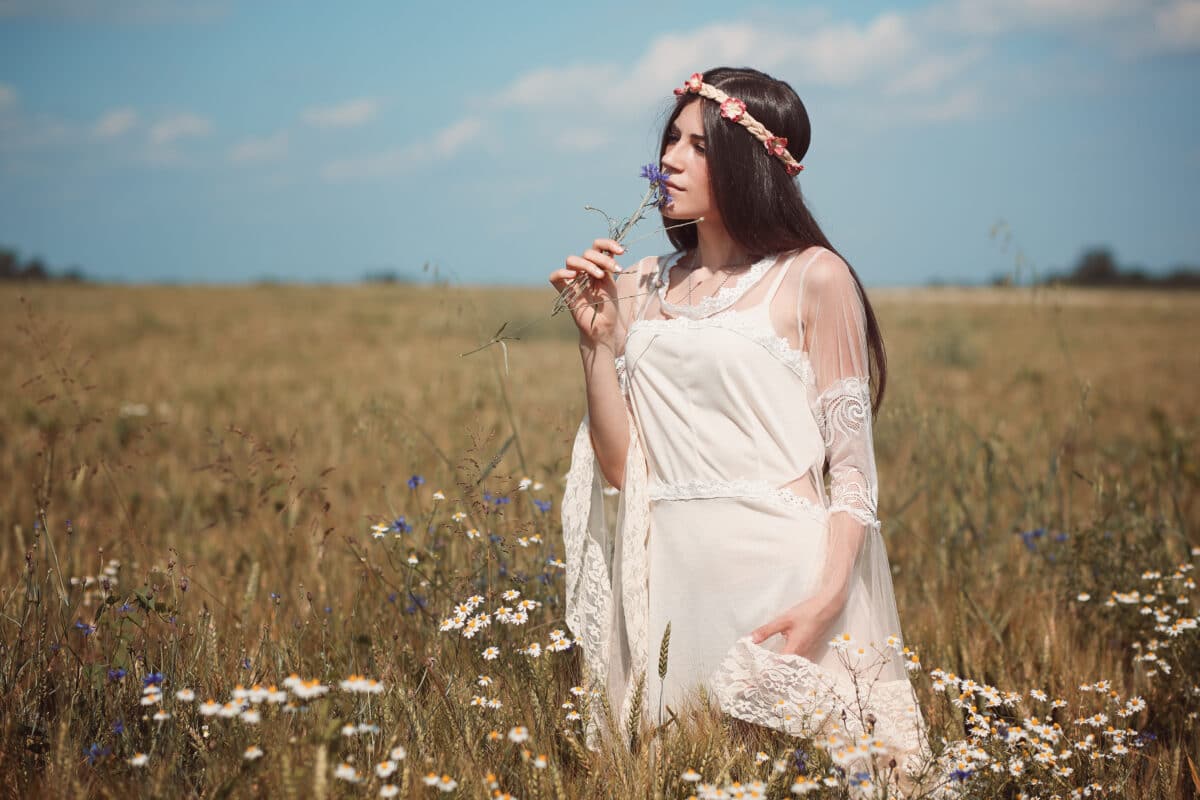 Innocent woman in summer field with white daisies
