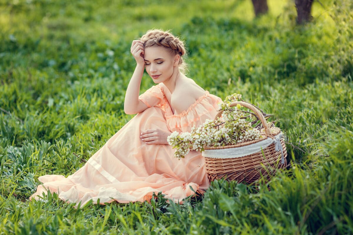 beautiful young lady in vintage dress in a pear-blossoming garden