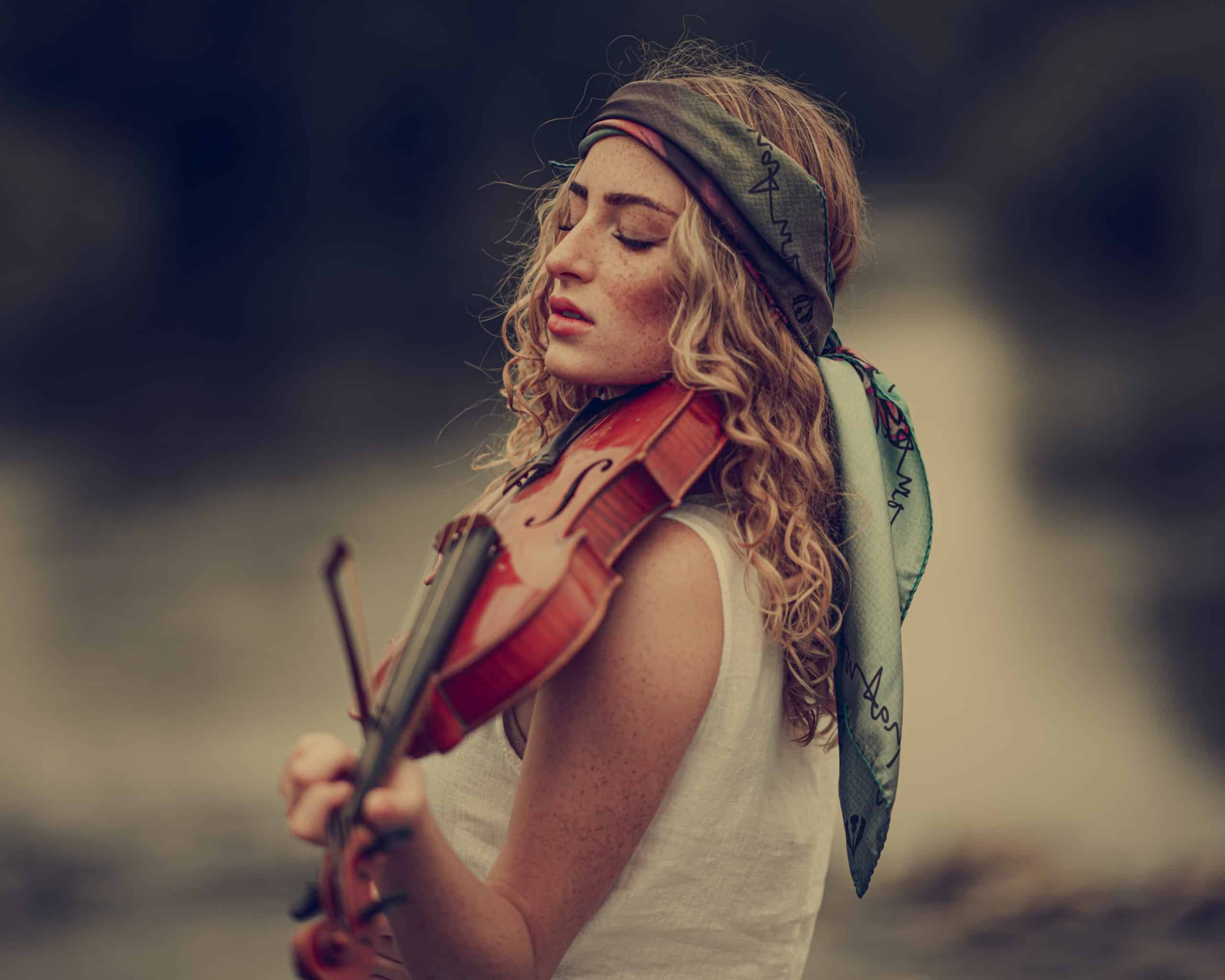 Boho woman playing the violin outdoor.