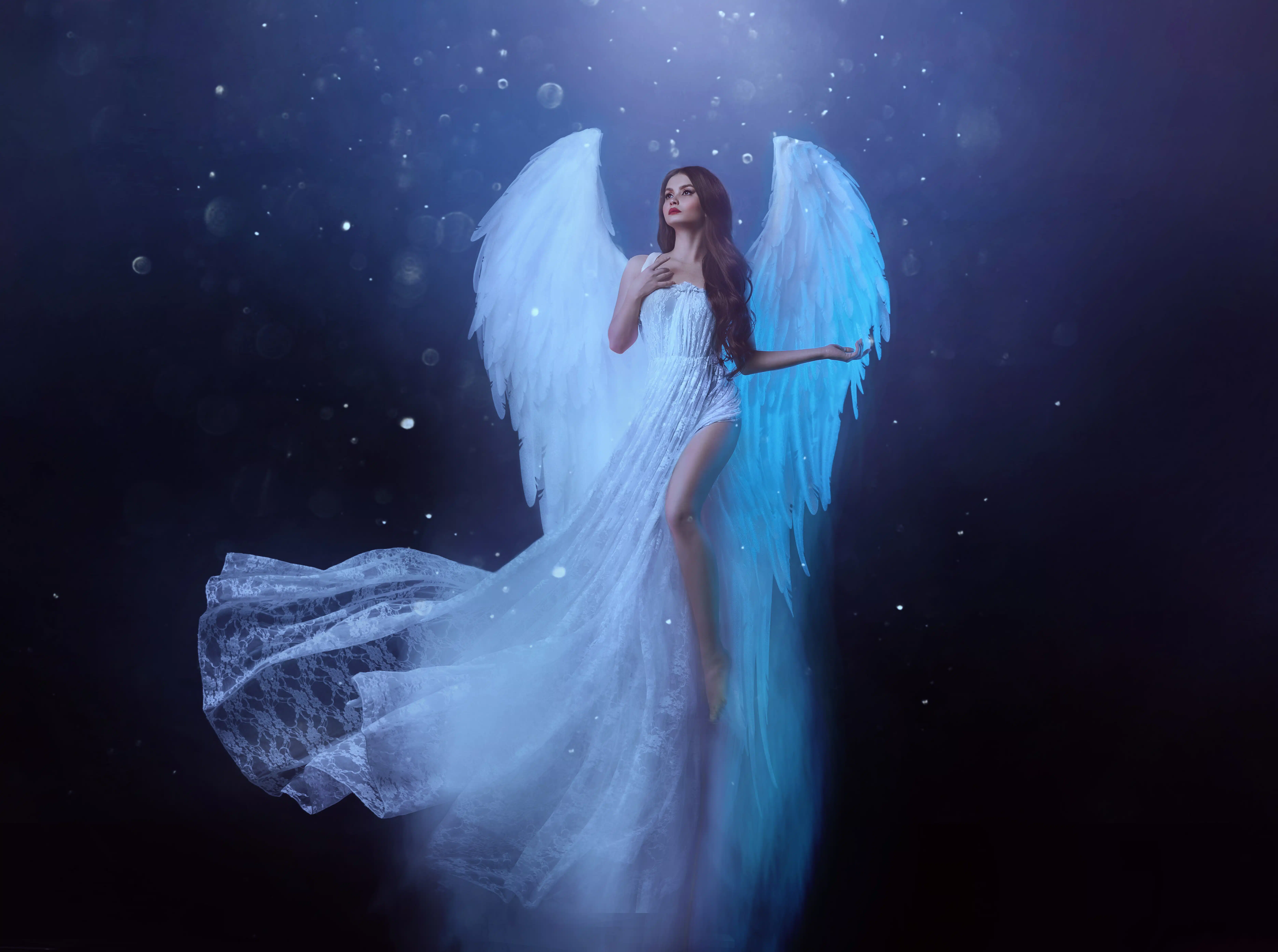 Fantasy woman angel soars in the air with white huge bird wings.