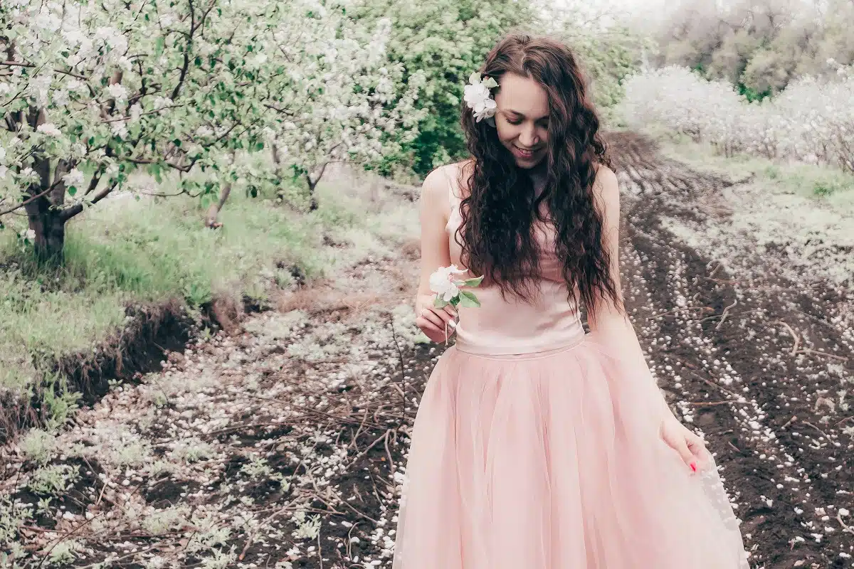 beautiful girl in a peach dress in the apple orchard