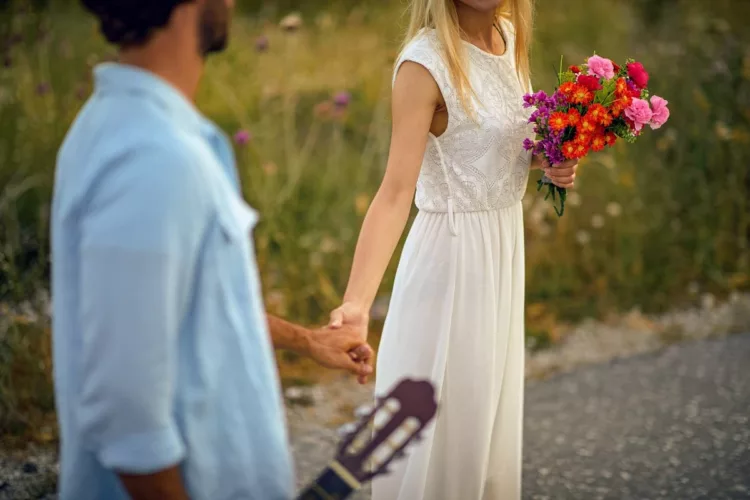 Bohemian style wedding couple holding hands and walking. 