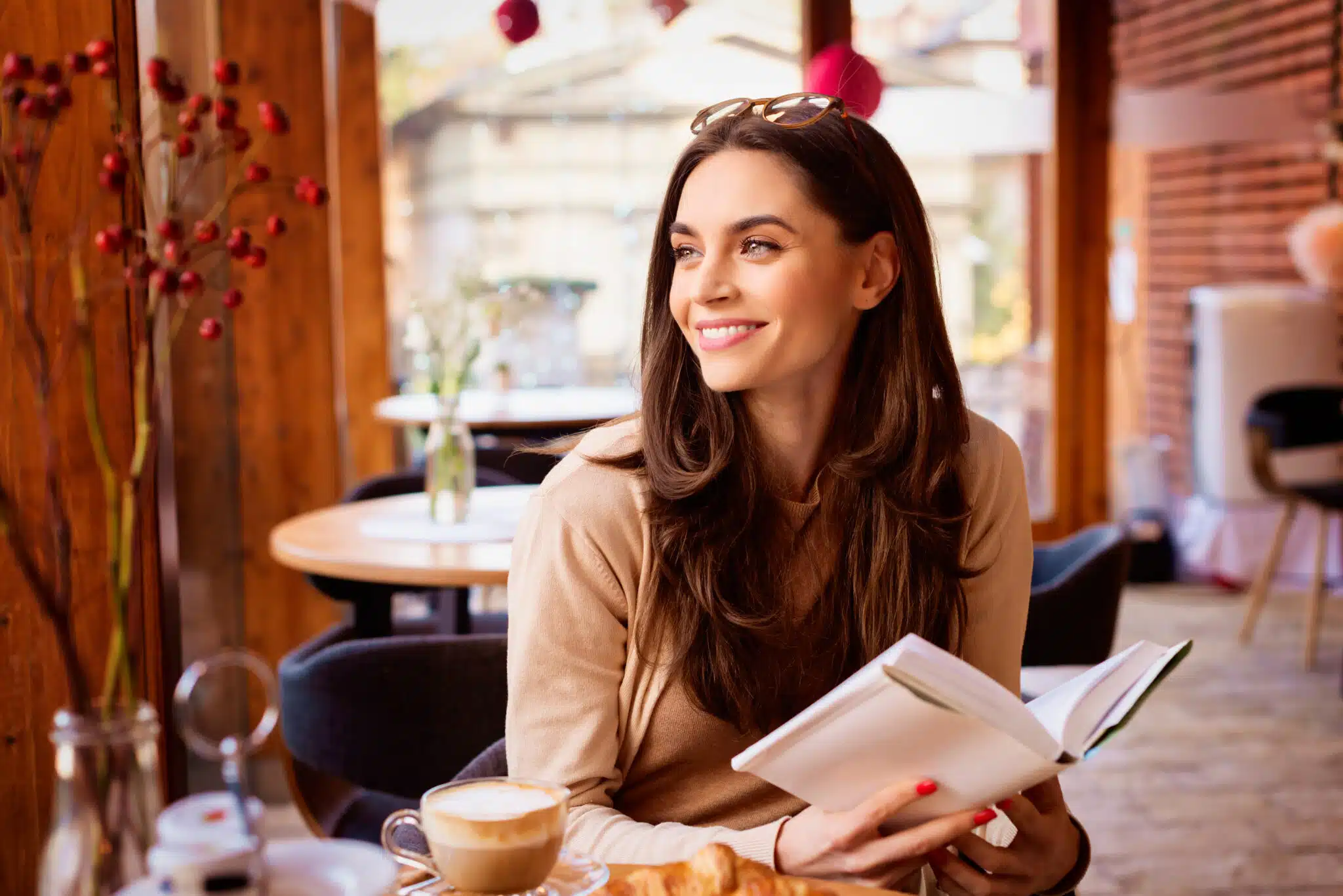 Attractive woman sitting in the cafe and reading book