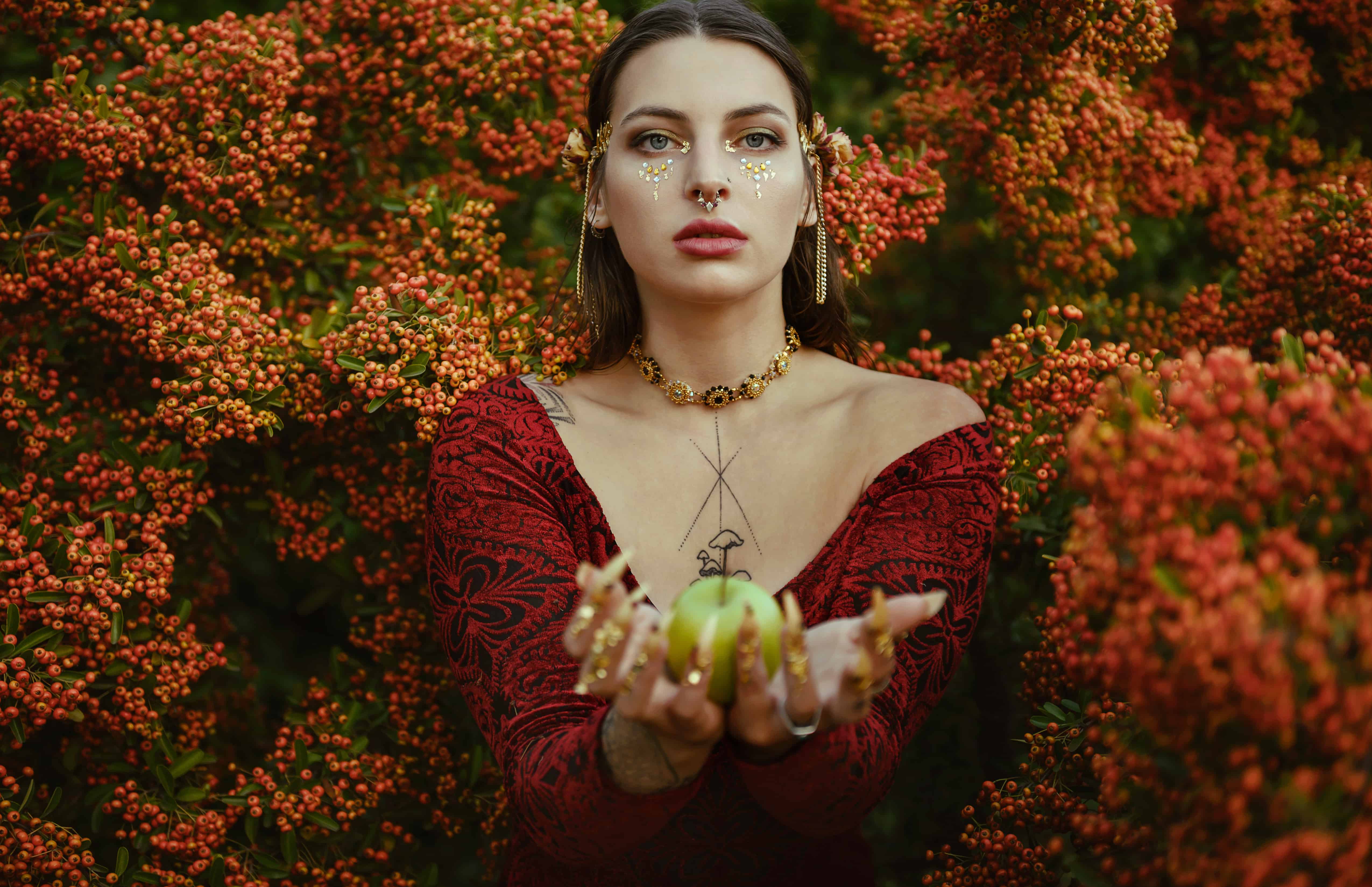 Snow White, young female with witchy vibes surrounded by red berries, is giving menacing glances