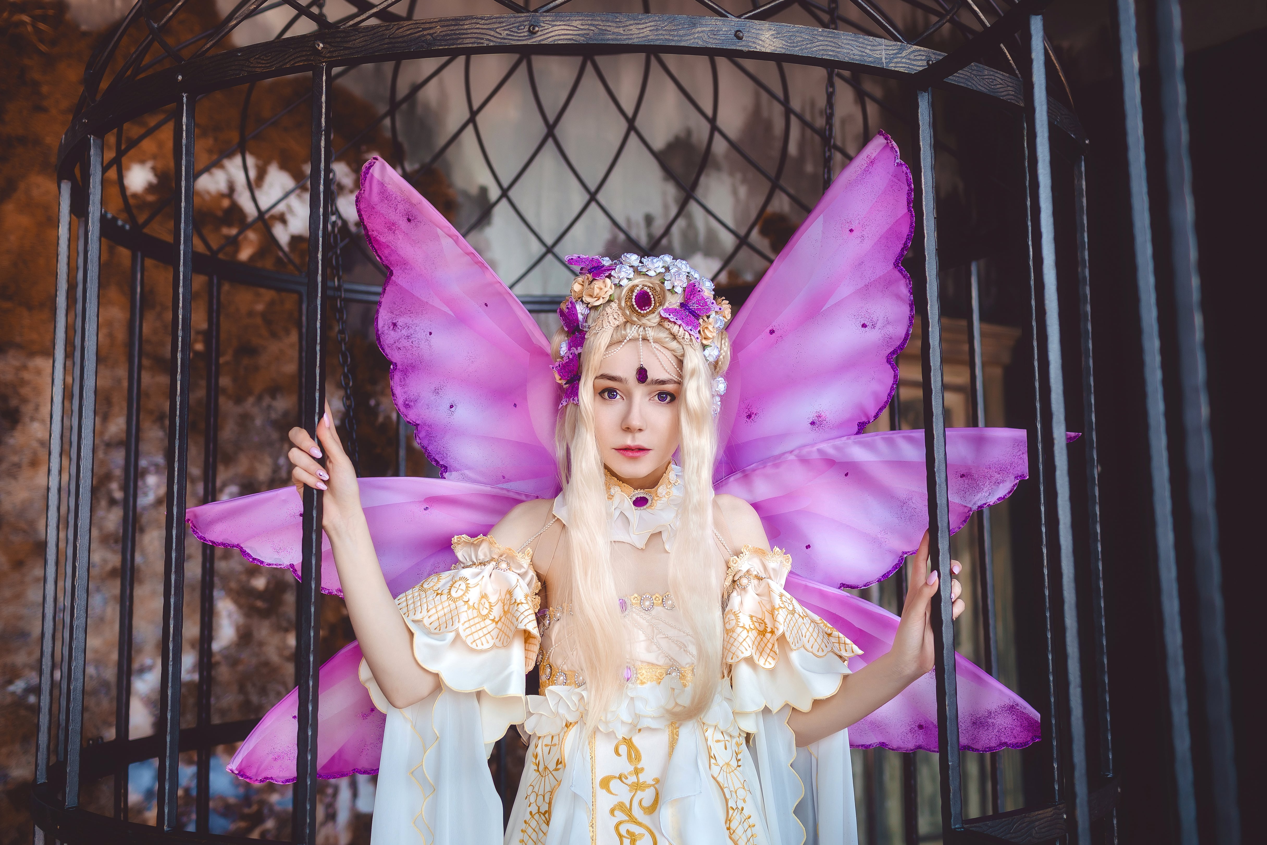 Young attractive girl dressed as fairy in the cage